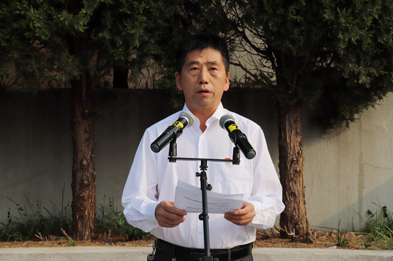 礼兵向革命烈士敬献花篮后,徐广友为花篮整理缎带.